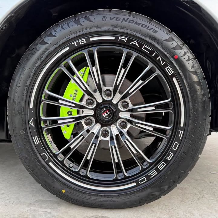 ล้อแม็กซ์และคาลิเปอร์สีเขียวของรถในลาน